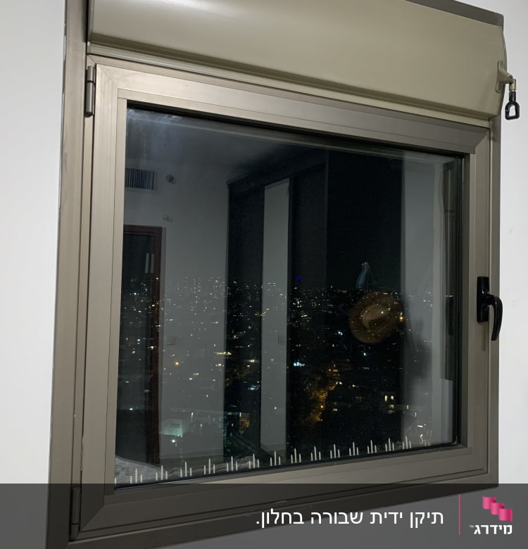 חלון עם תריס גלילה סגור חלקית